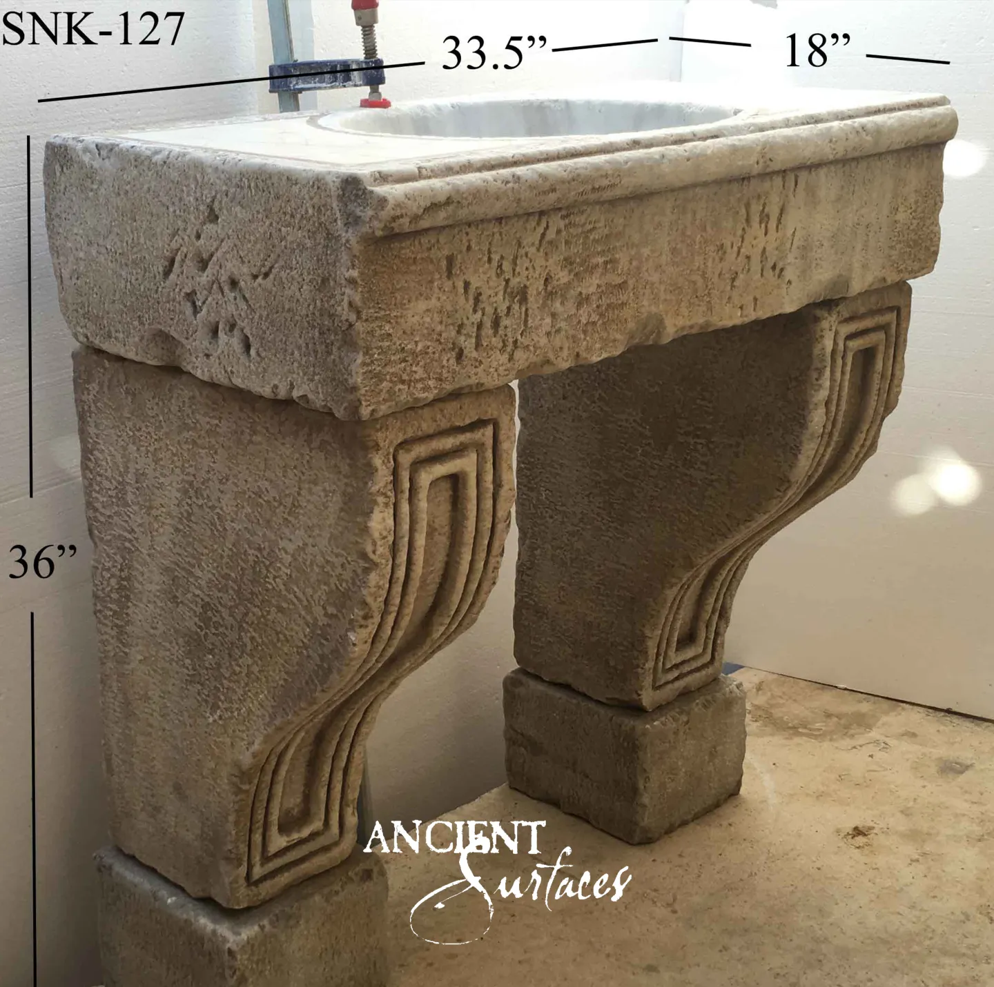 Ochre antique limestone sink from Ancient Surfaces with a marble basin insert and corbel legs cut with a Greek key return