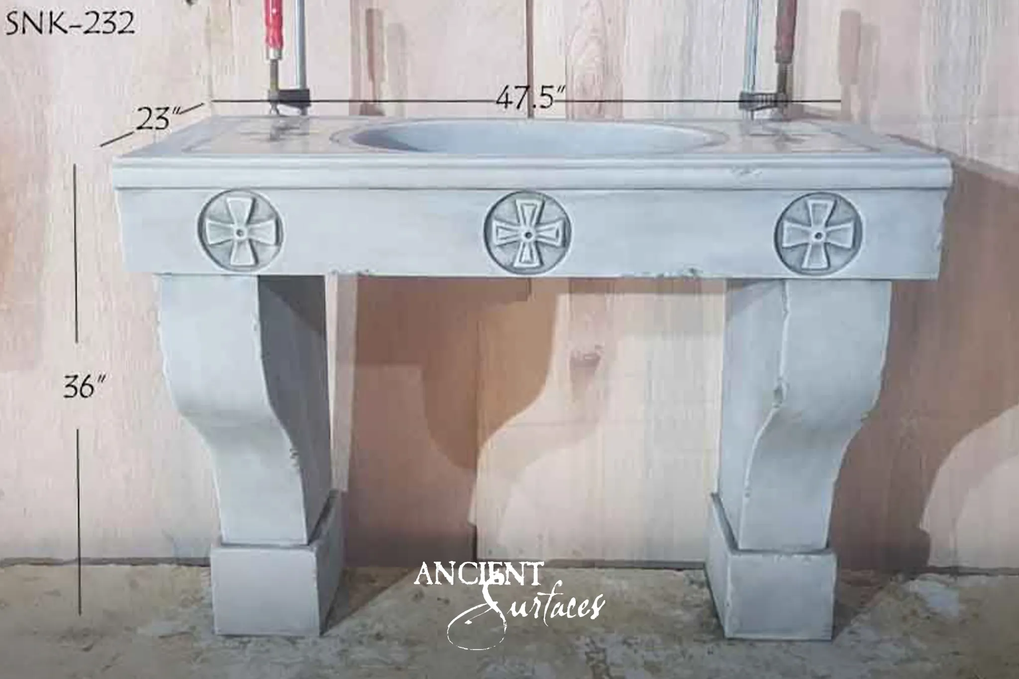 Pale grey antique limestone console sink from Ancient Surfaces with three carved cross rosettes across the apron